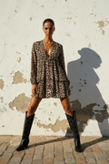 Langarm Minikleid mit Leopardenprint und Volants, Model mit Cowboy Stiefeln an heller Wand