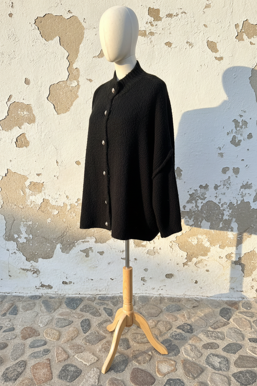 Oversized Cardigan Schwarz – Model seitlich an Wand gelehnt mit Gürtel